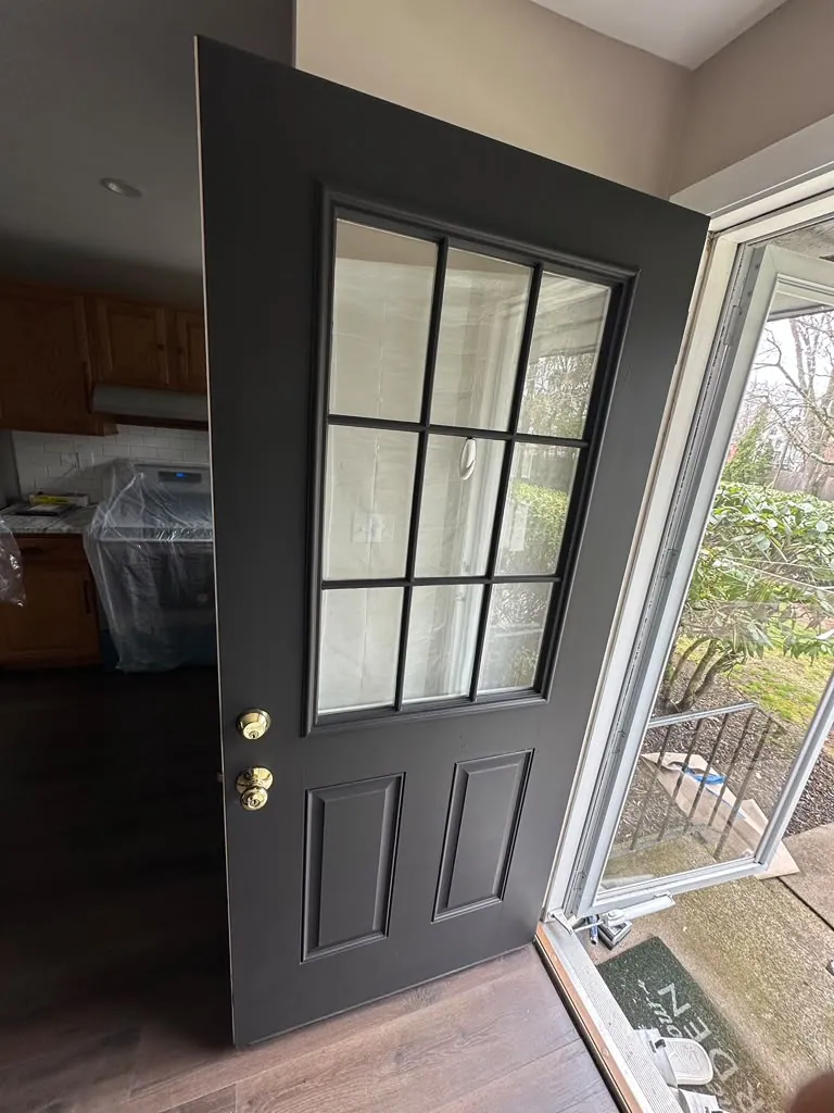 Entry door finished in deep charcoal, smooth and even